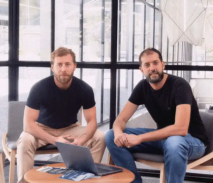 Iñaki Mediavilla y David Martín-Borregón sentados frente a un portátil en la oficina